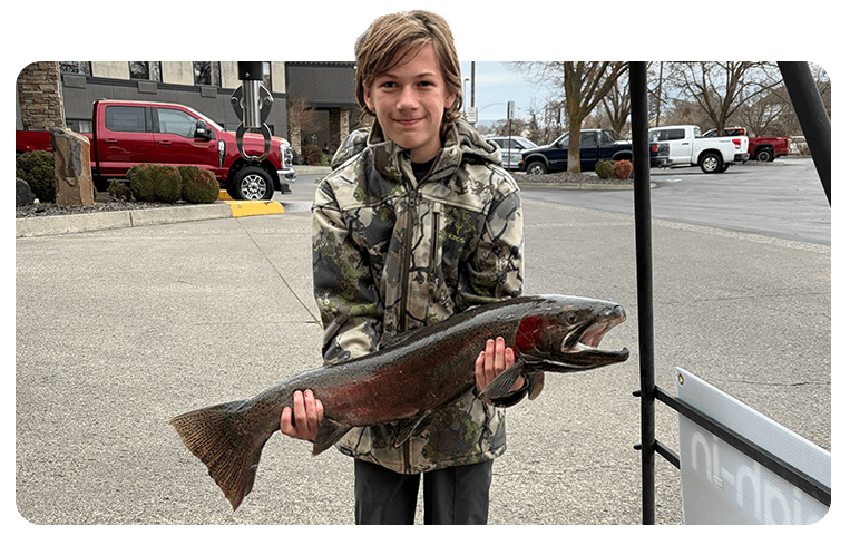 Youth angler holding a steelhead