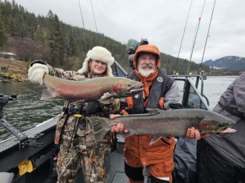 Man and Girl Holding Fish on Boat